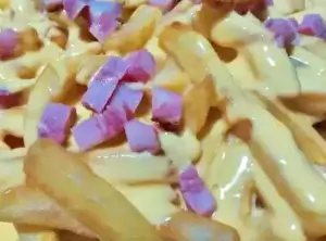 al plato con papas fritas mas salsa cheddar y panceta